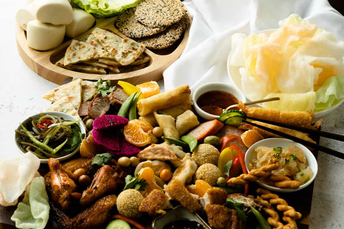 Asian charcuterie board with complimentary buns, wrappers and chips.