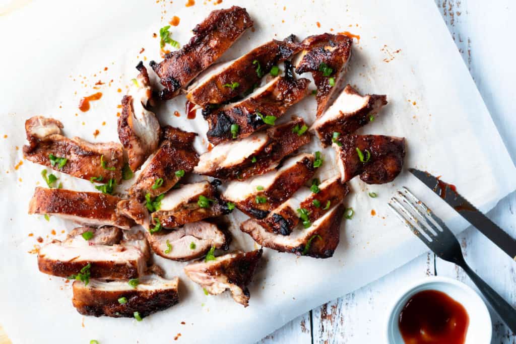 Char siu chicken slices on a board.