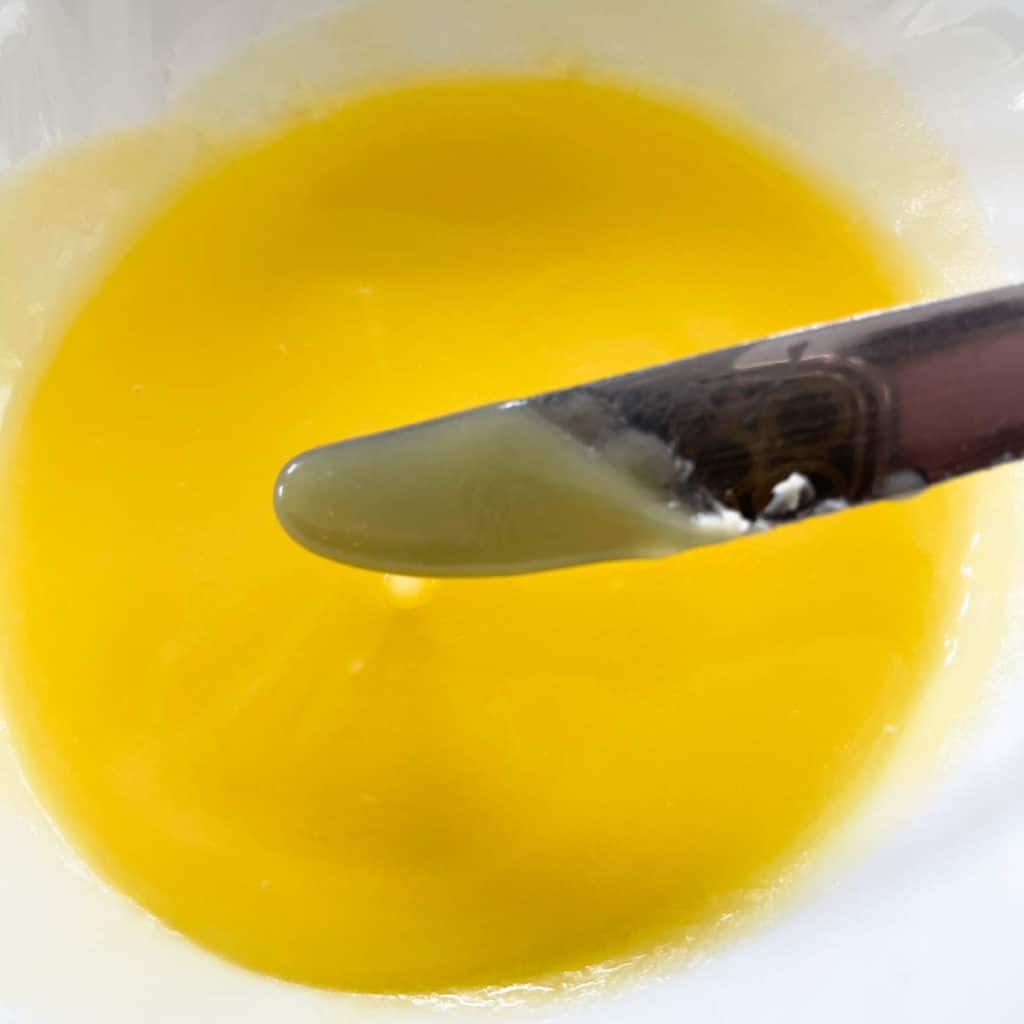 Cooled melted butter coating a butter knife.