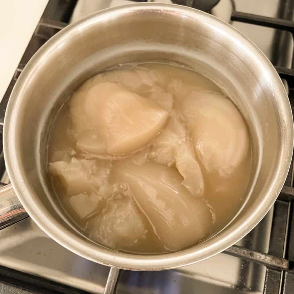 Chilled chicken foot soup is jelly like in a pot.