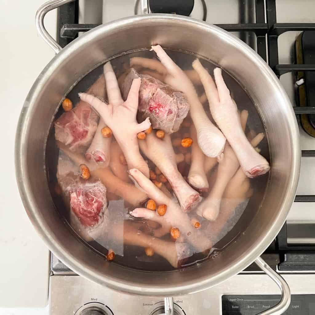 Place your chicken feet, pork bones and peanuts in water and bring to a rapid boil.