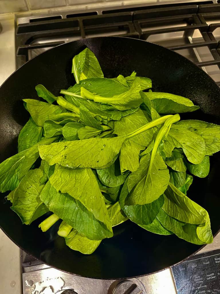Yu choy in hot wok.