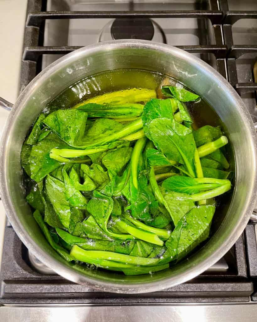 As yu choy blanches it becomes darker in color.