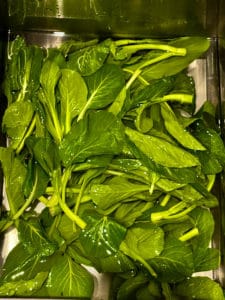 Clean yu choy by soaking it in water.