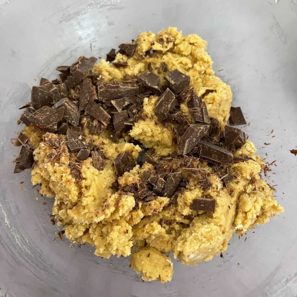 Chopped chocolate added on top of cookie dough.
