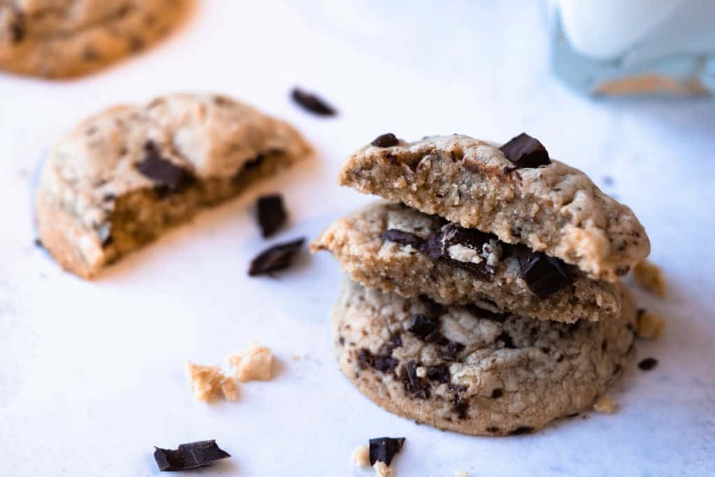 Chocolate chip cookies broken in half to show soft thick centers.