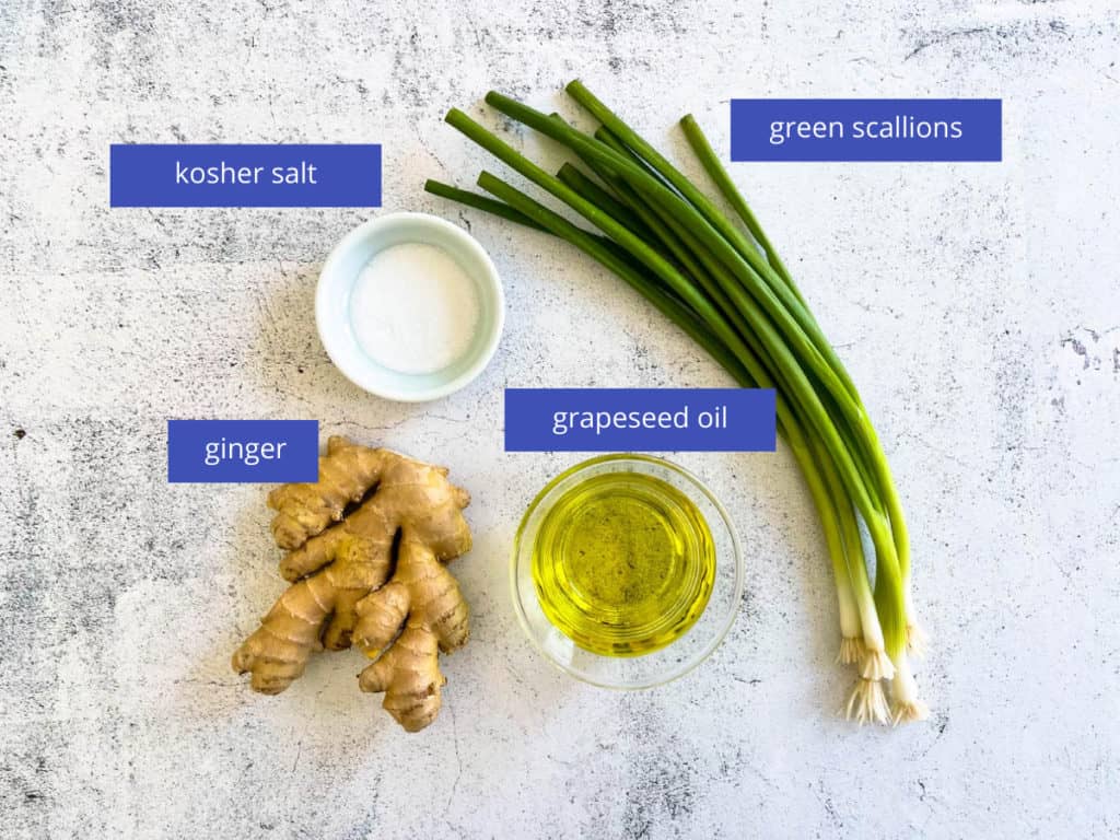 Ginger, oil, scallions and salt laid out on a table. The ingredient for ginger scallion sauce.