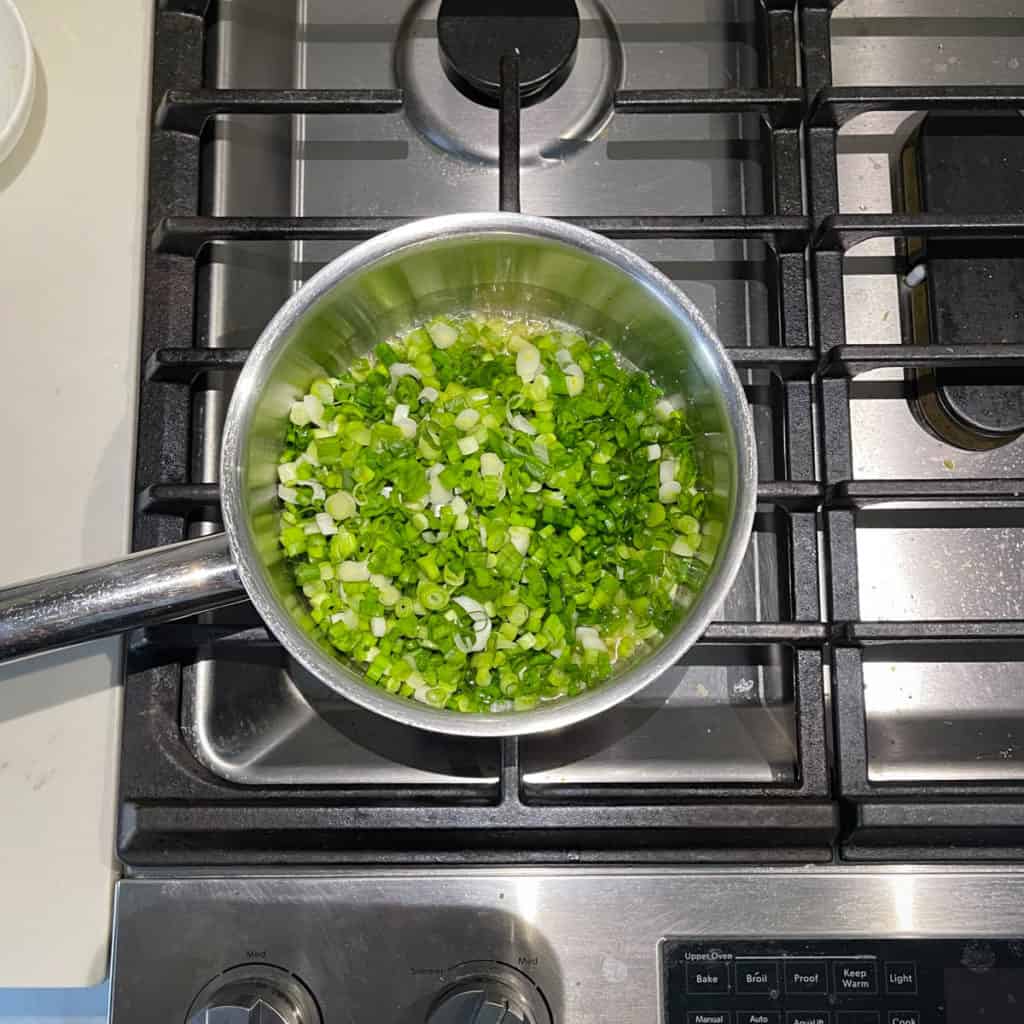 Raw green onions in a pot.