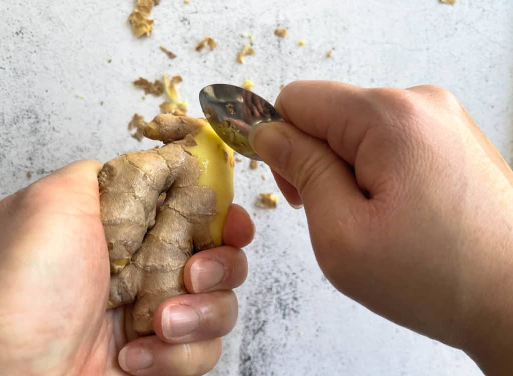 Peeling ginger with a spoon.
