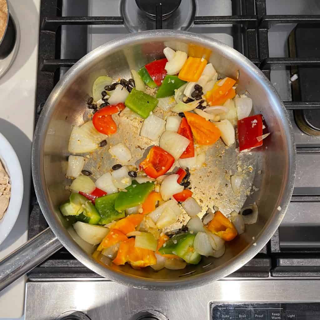 Black beans, onions and peppers frying in a pan.