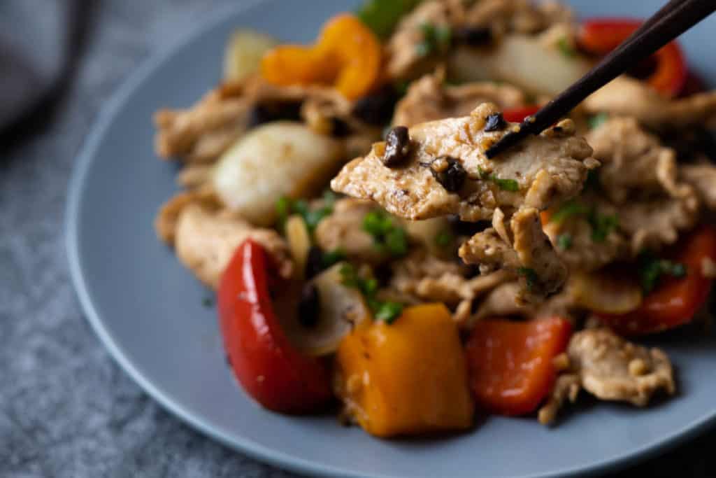 Close up of a slice of chicken from black bean chicken.
