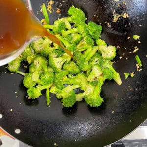 Stir fry sauce being poured into a pan.