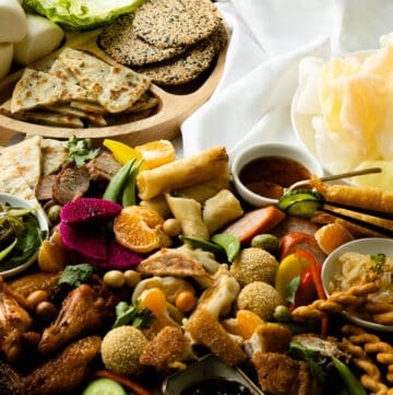 Asian charcuterie board with complimentary buns, wrappers and chips.