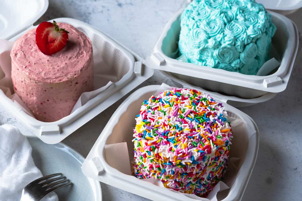 Three lunchbox cakes in their boxes.