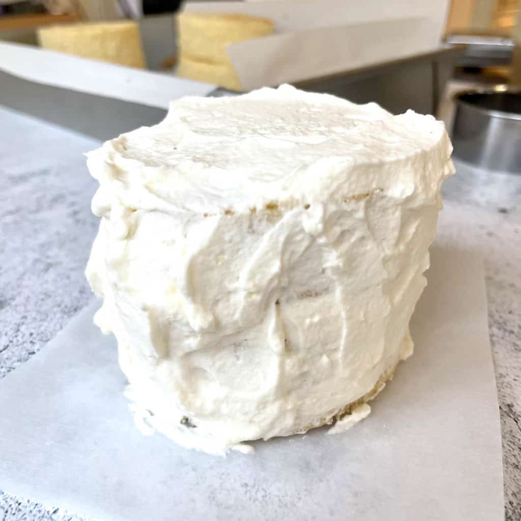 Frosting covering the lunch box cake but not smoothed.