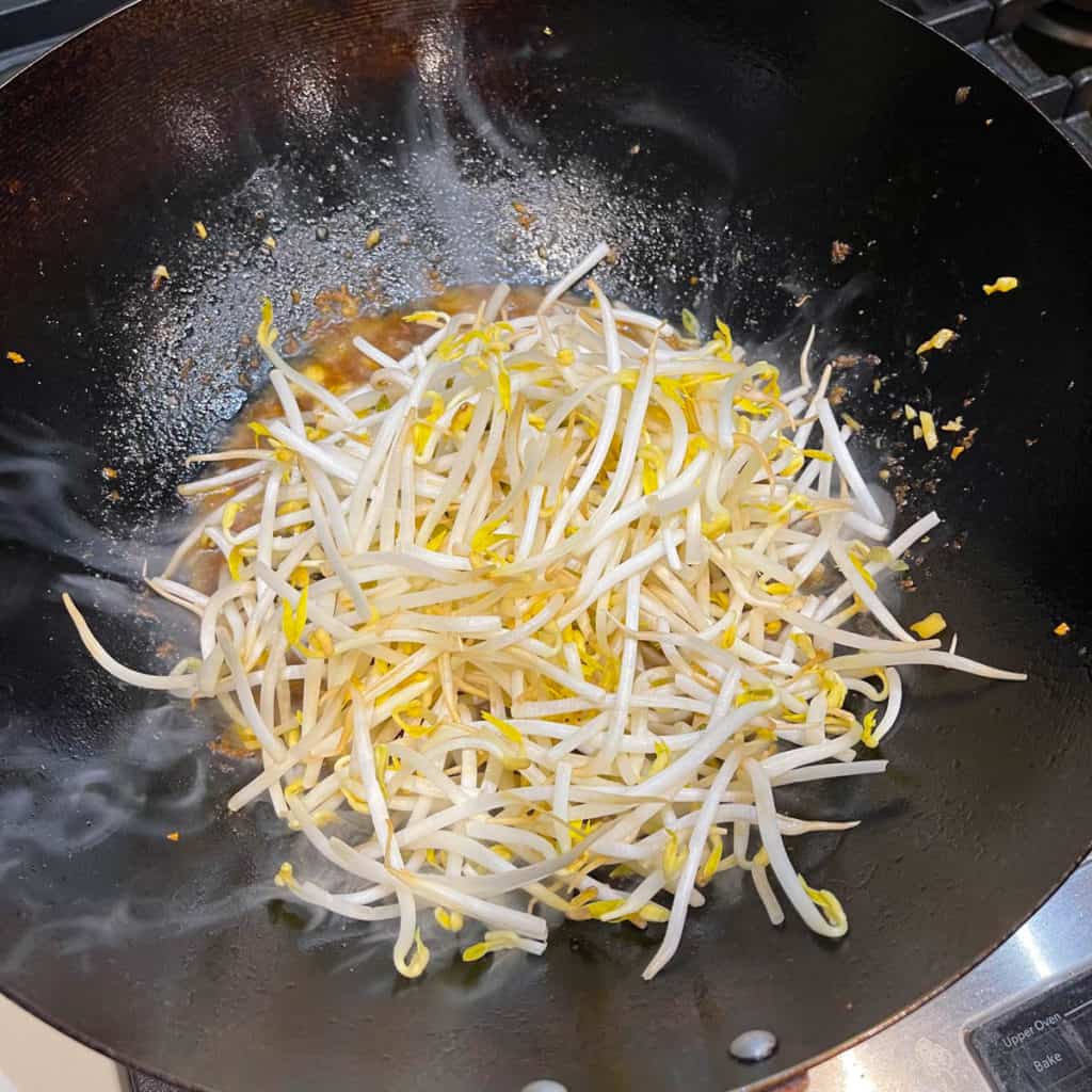 Bean sprouts simmering in brown sauce.