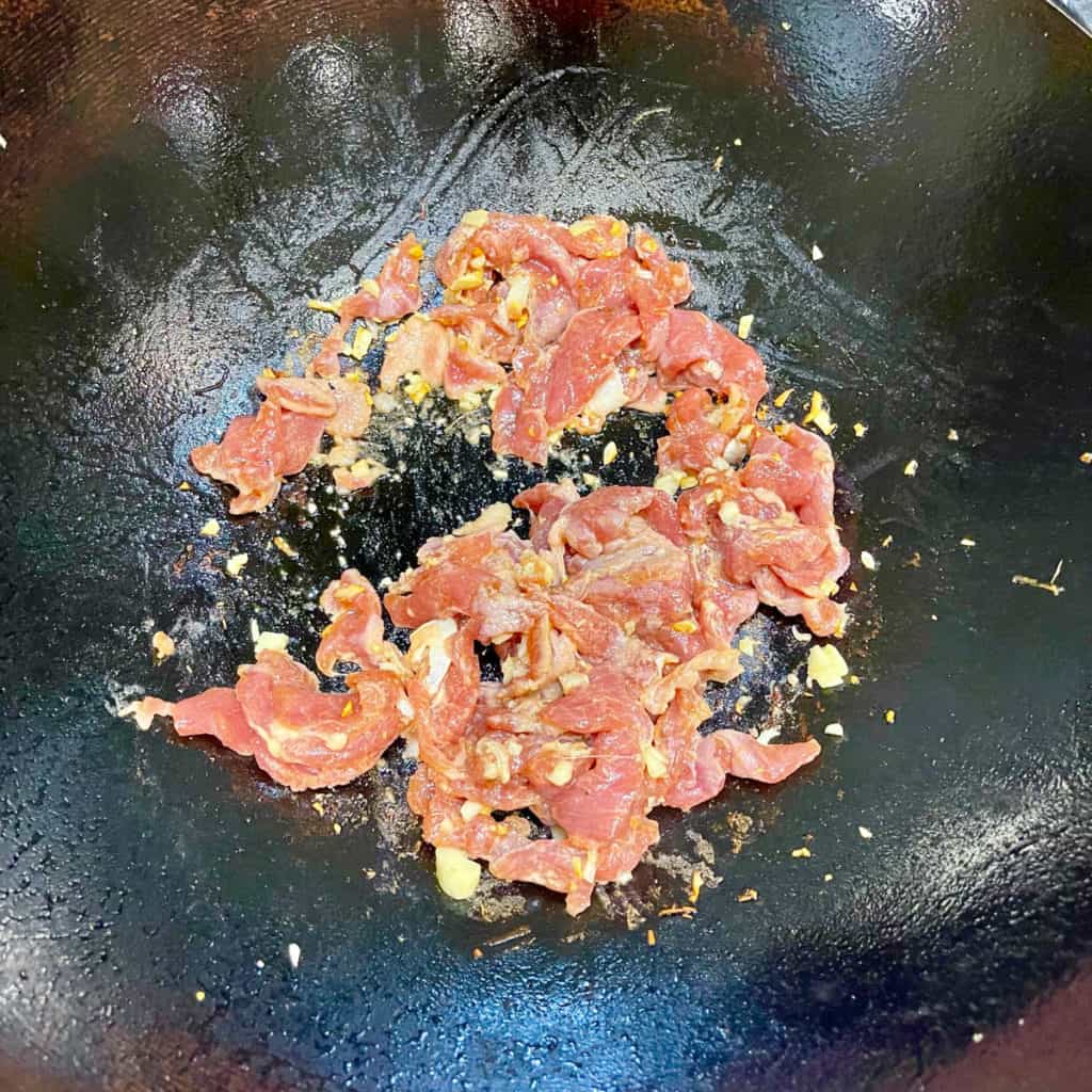 Pork tenderloin frying in a wok.