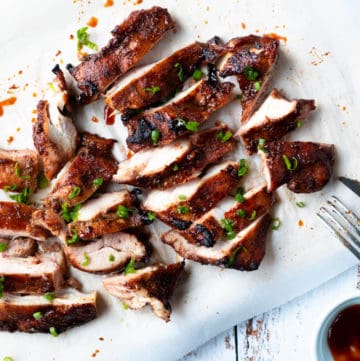 Slices of char siu chicken on a board.