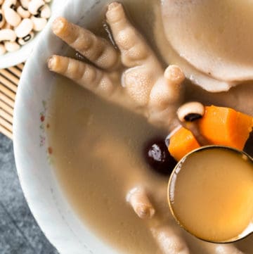 Spoon of chicken foot soup in a bowl.