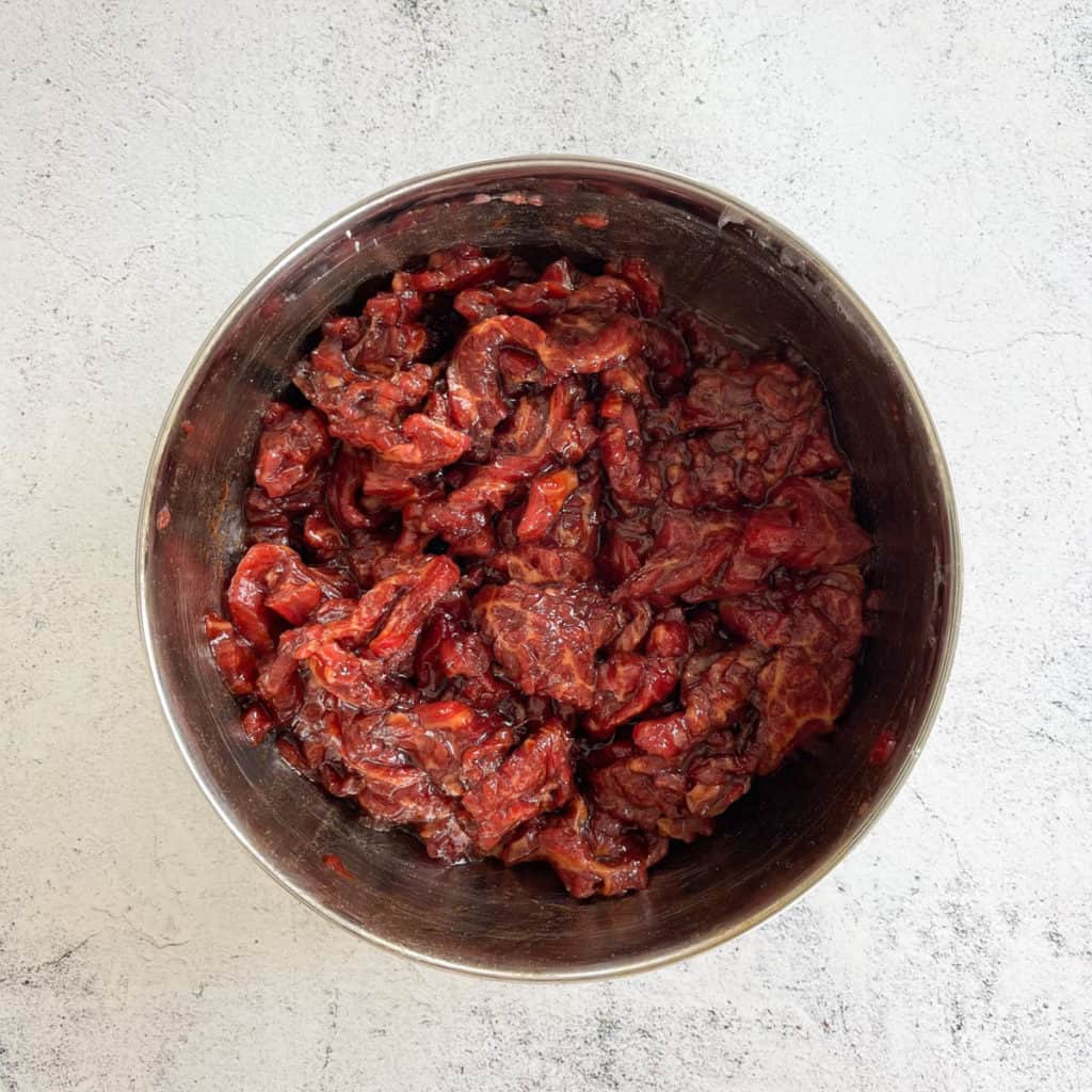 Bowl of beef slices with marinade.