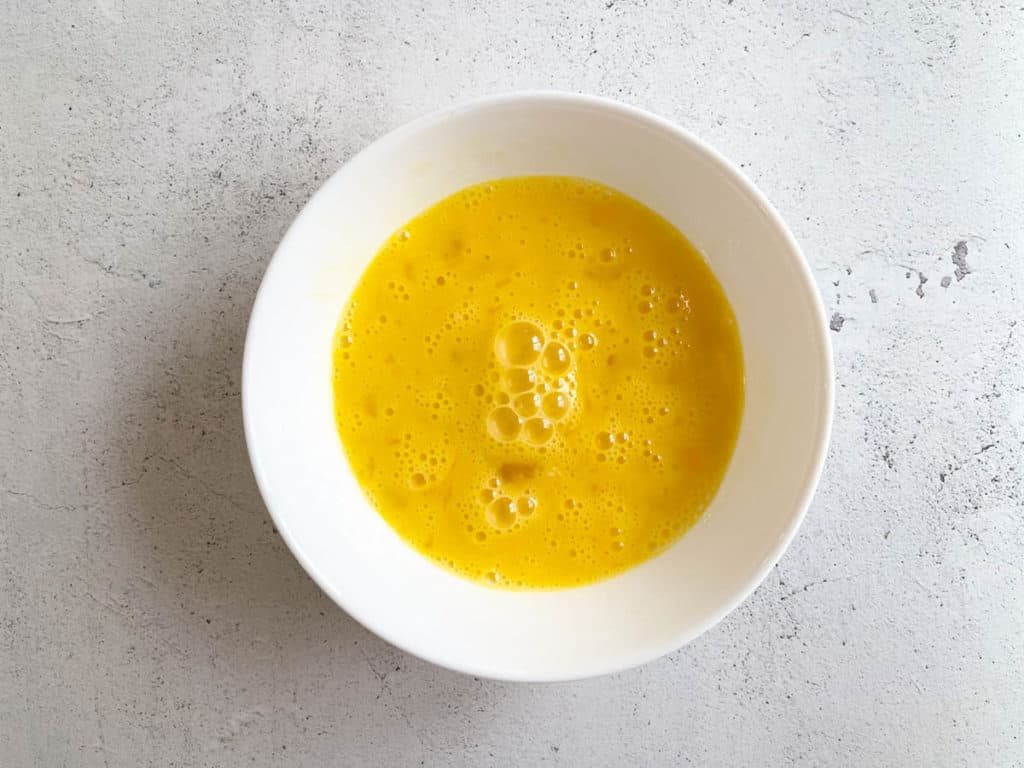 Beaten eggs in a bowl.