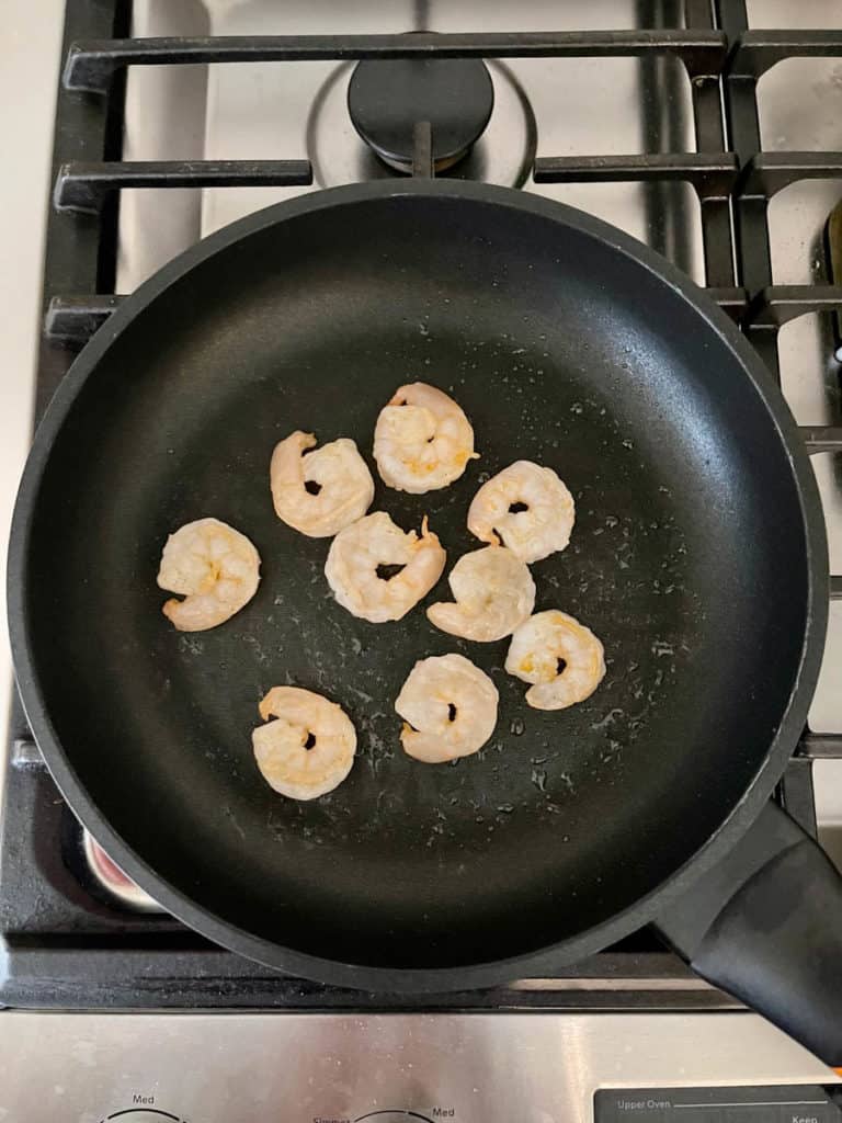 Pink shrimps almost cooked in pan.