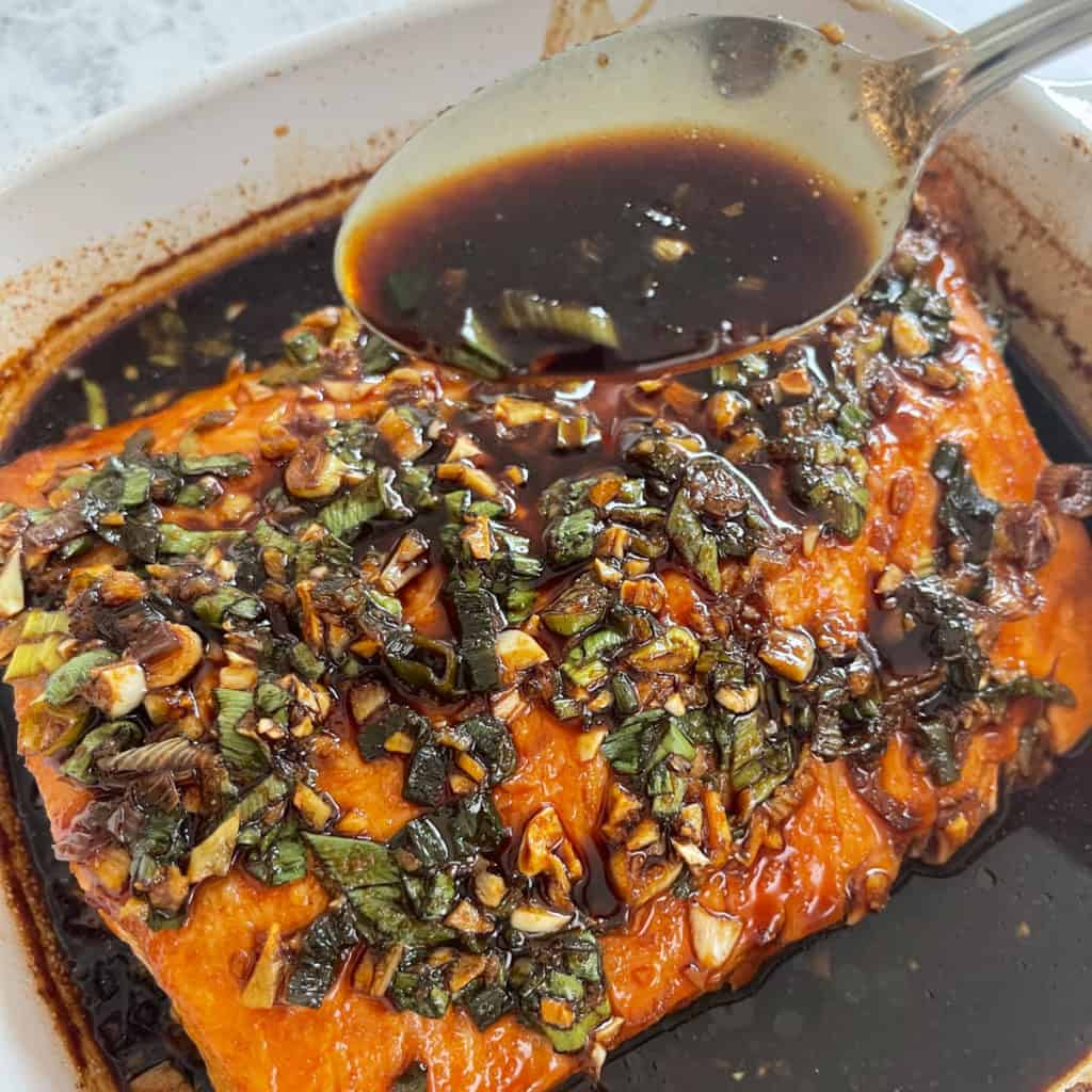 Basting salmon fillet with a spoon. 