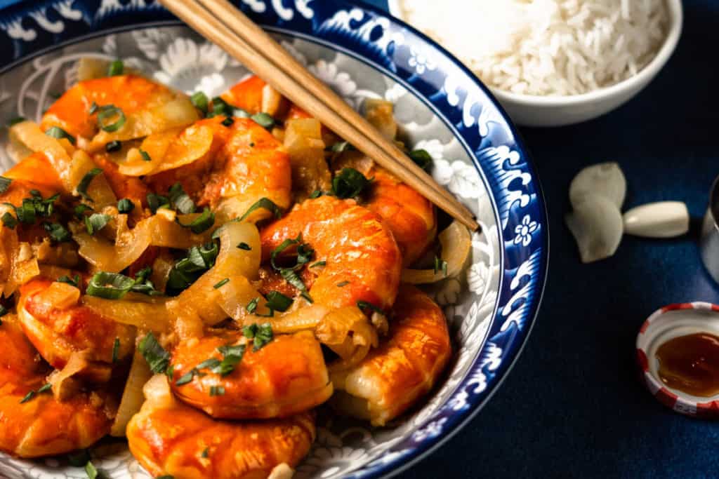 Stir fried shrimp in ketchup sauce on a plate.