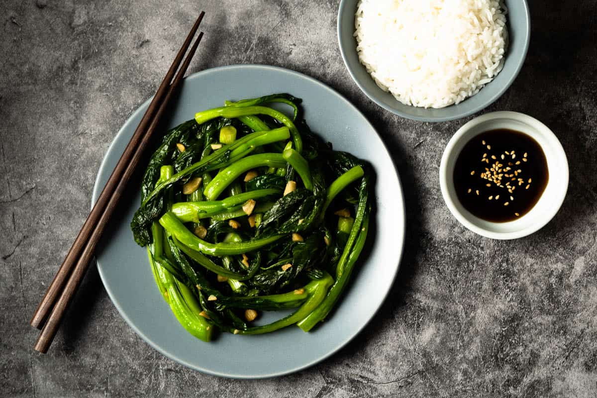Yu choy sum on a plate with rice.