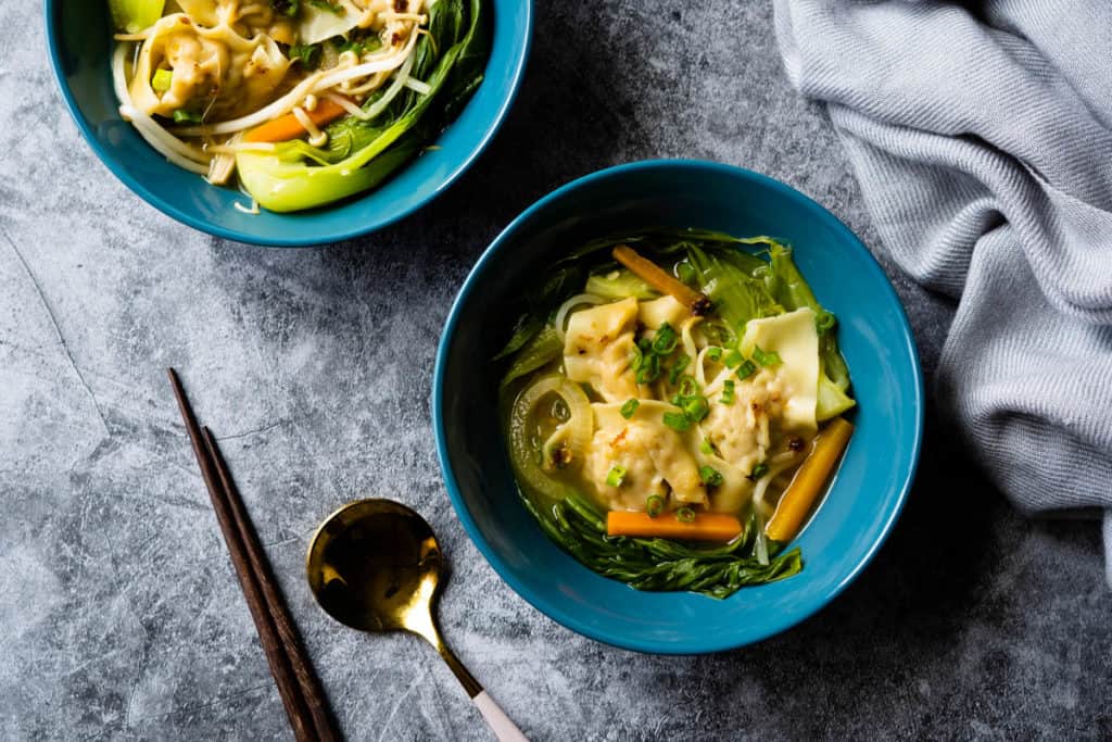 Two bowls of vegetable wonton soup.