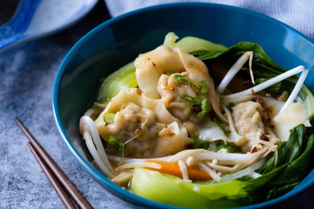 Close up of vegetable wonton soup with bok choy.