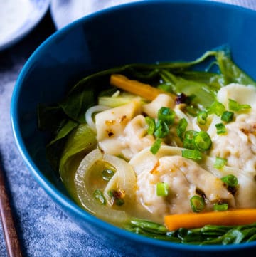 Vegetables and wonton soup in a bowl.