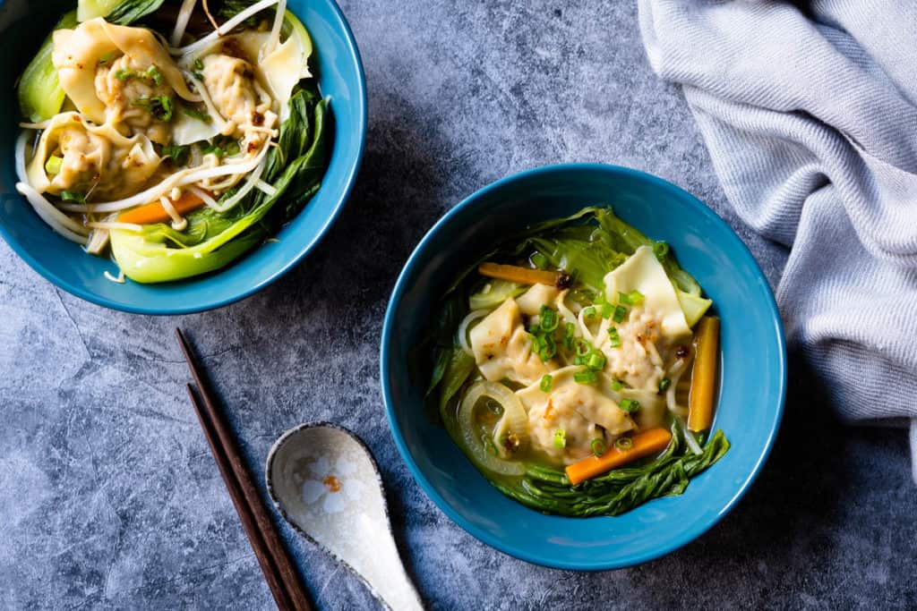 Two bowls of vegetable wonton soup.