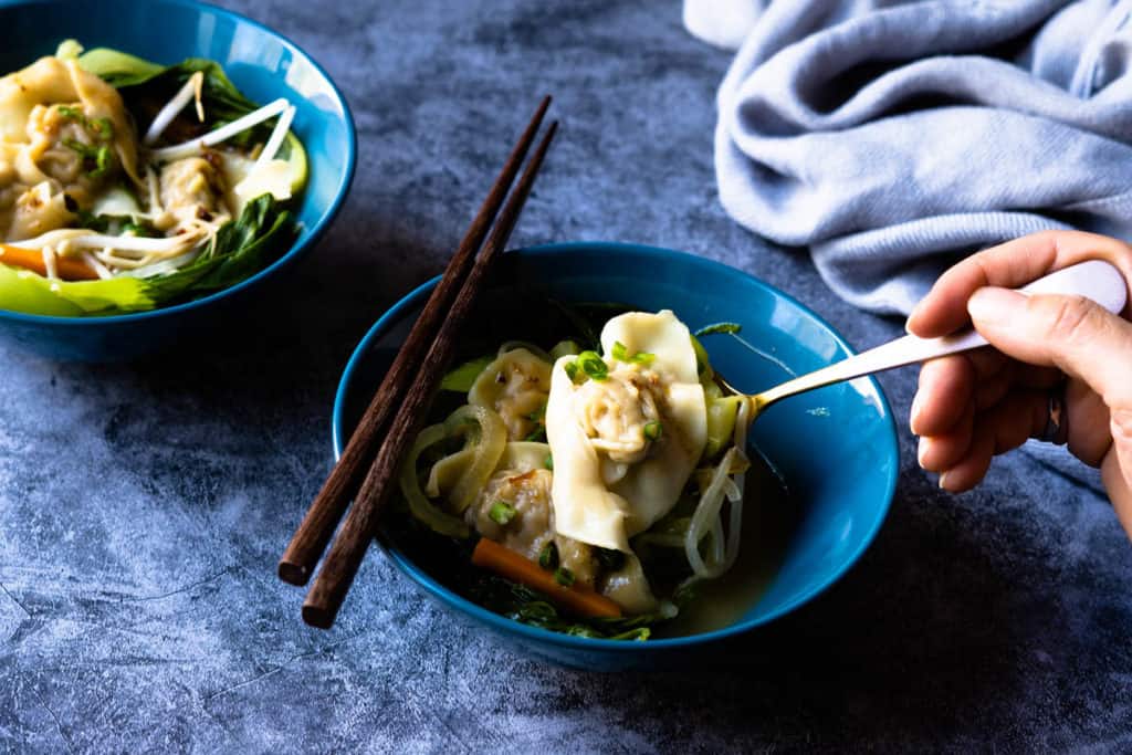 Wonton soup bowl with spooned wonton.