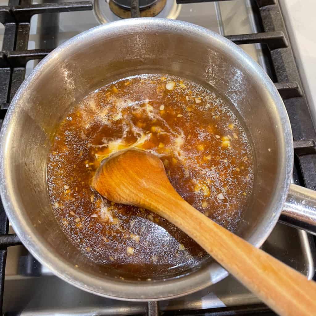 Thicken brown sauce by adding corn starch slurry.