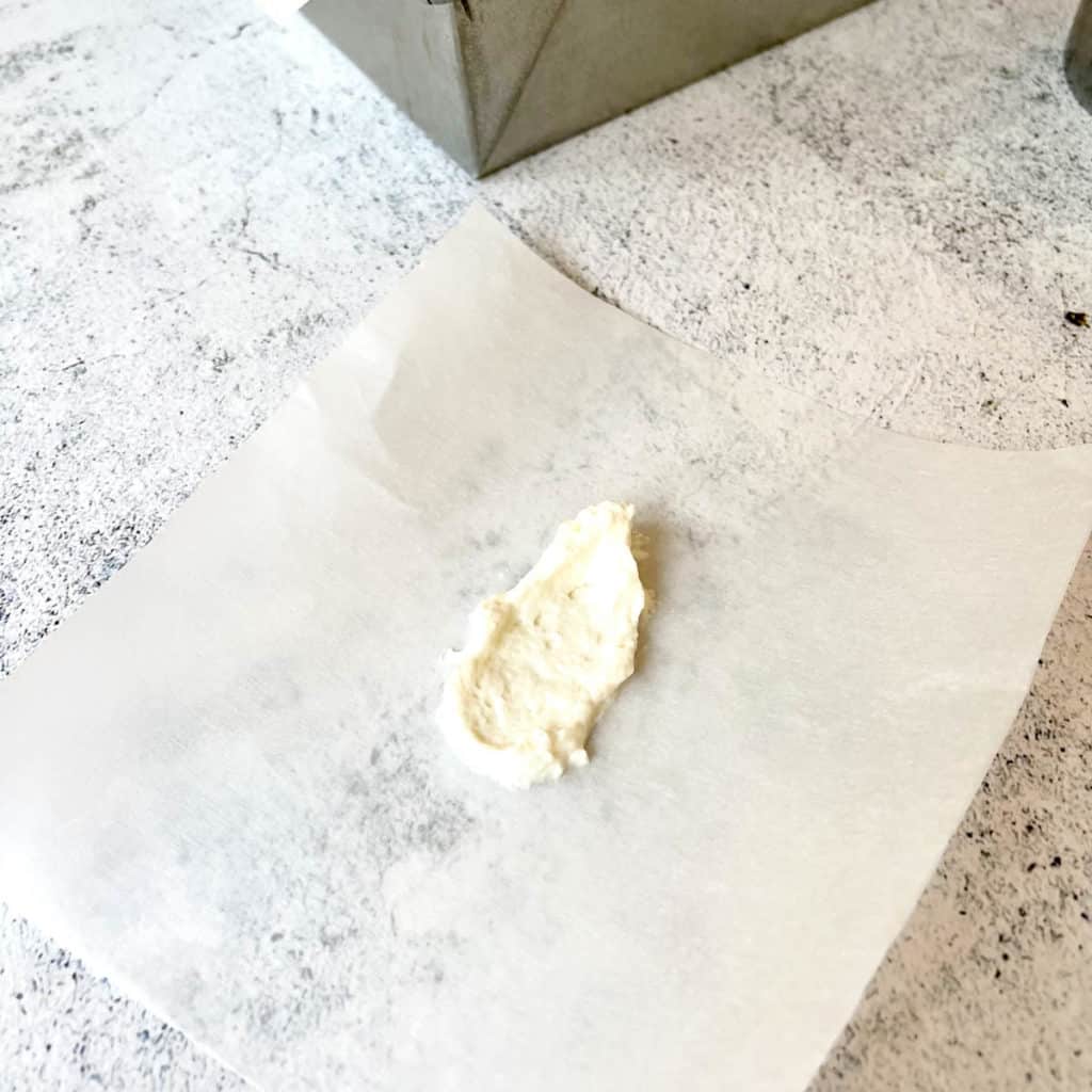 Dab of frosting on parchment paper.
