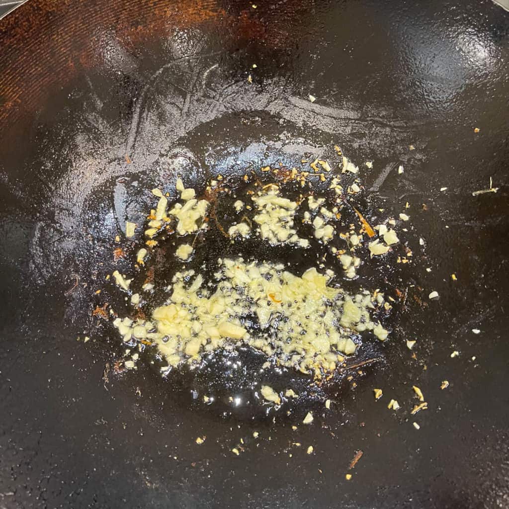 Minced garlic lightly frying in a wok.
