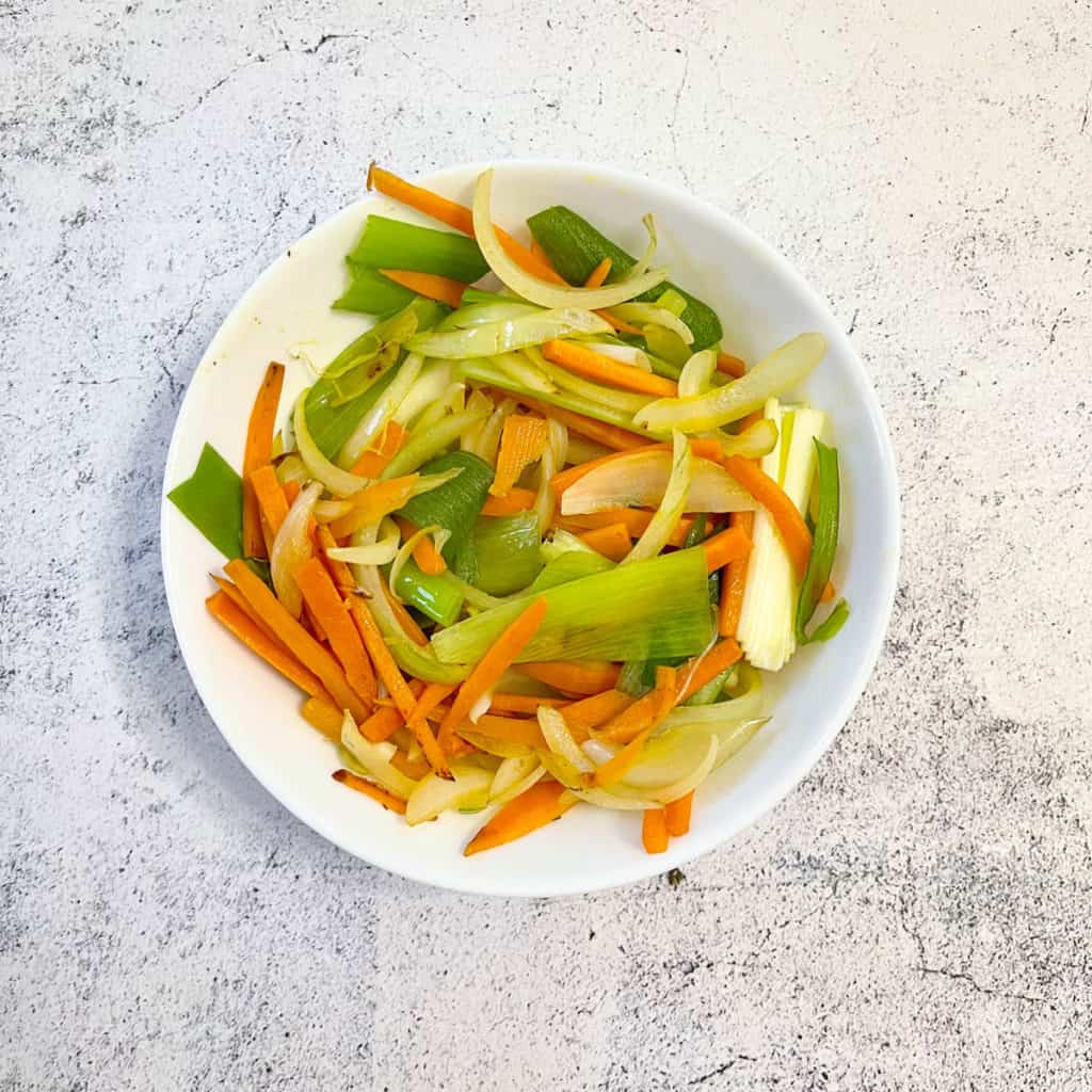 Carrots, onions and scallions in a bowl.