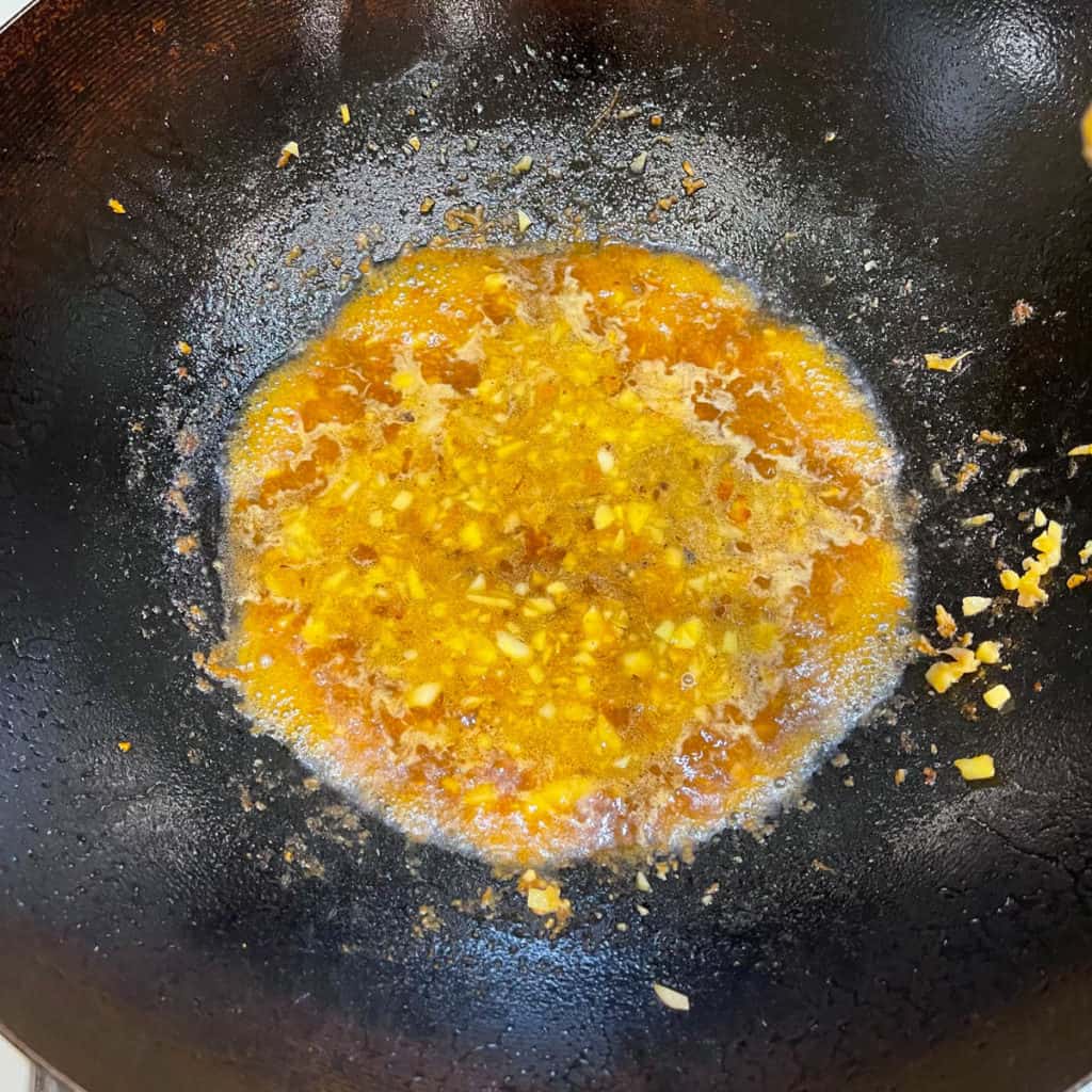 Simmering brown sauce in a wok.
