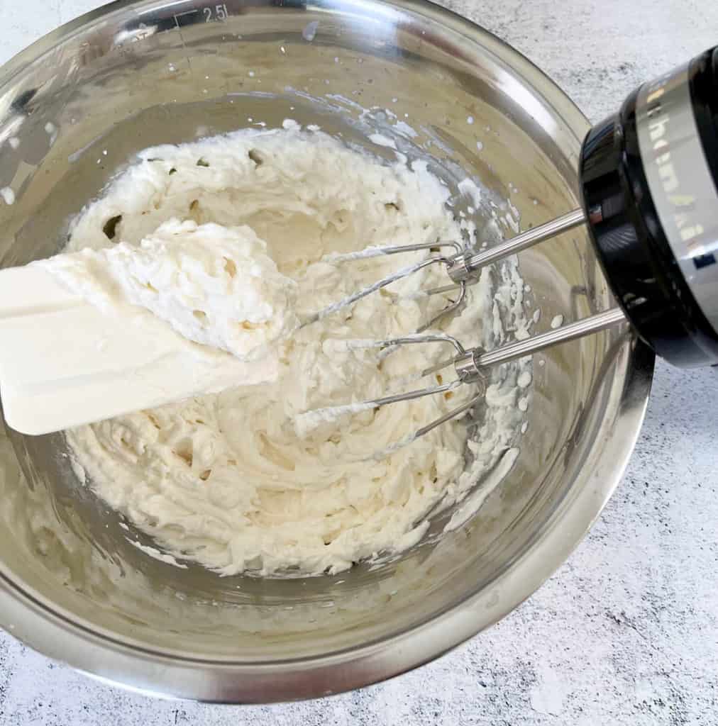 Whipped cream with stiff peaks.