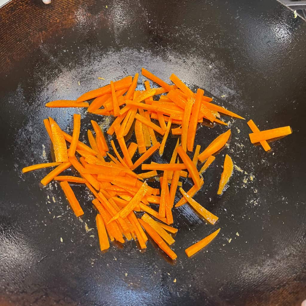 Carrots frying in a wok.