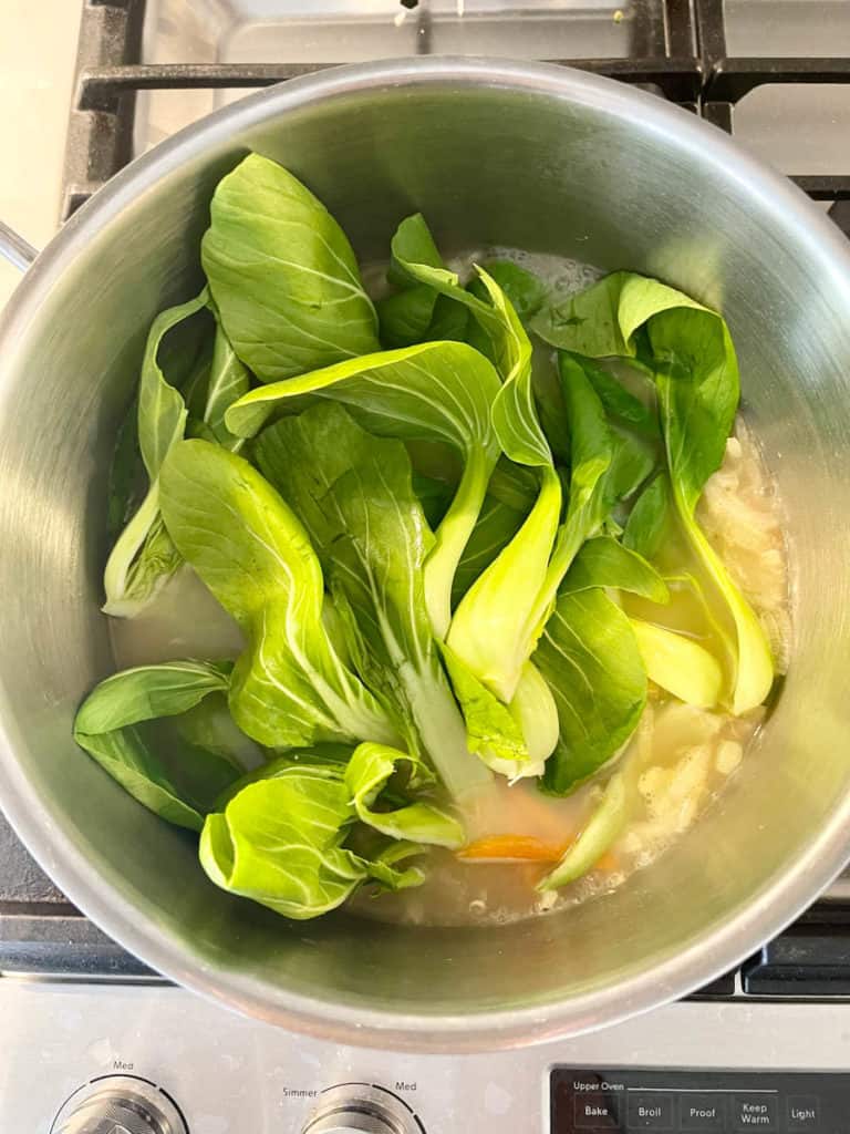 Shanghai bok choy in a pot of simmering broth.