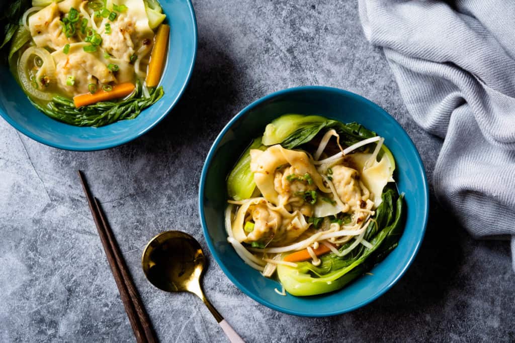 Two bowls of vegetable wonton soup.