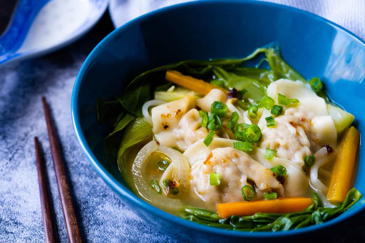 Vegetables and wonton soup in a bowl.