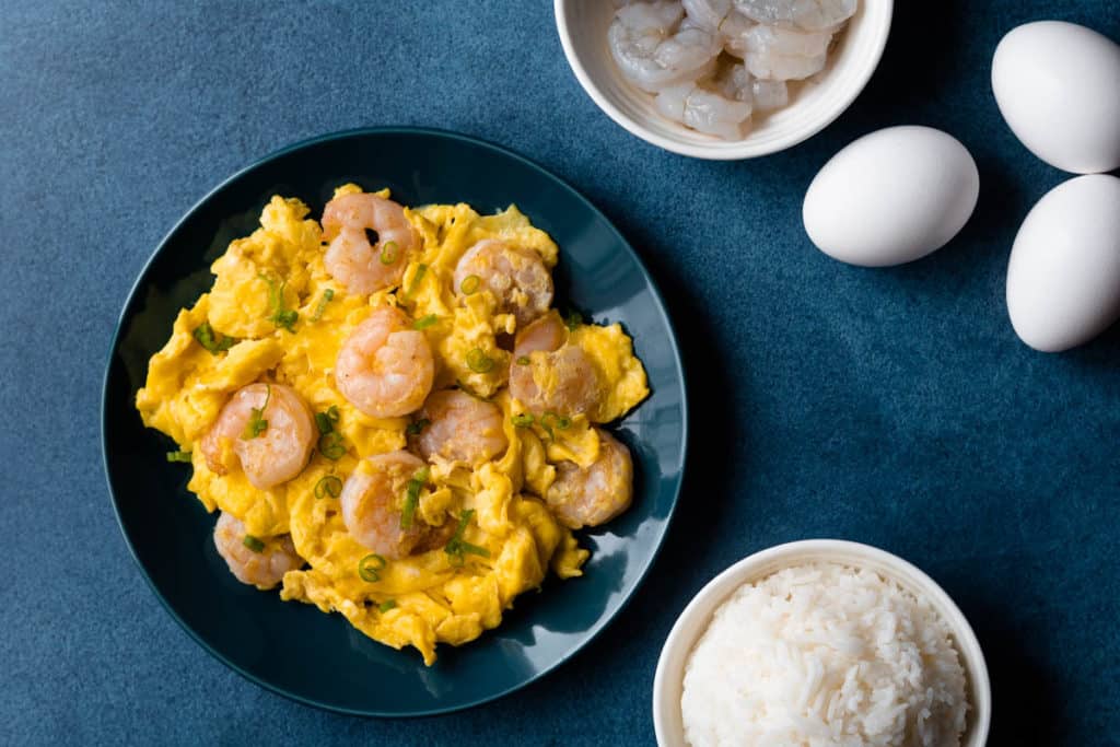 Shrimp omelet flat lay with bowl of rice and whole eggs.