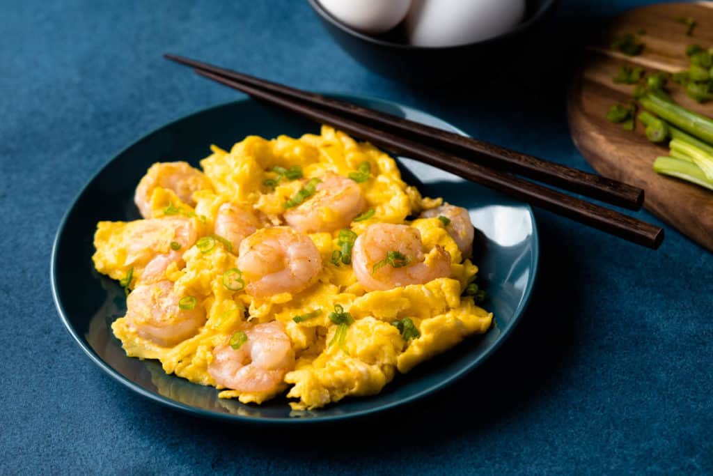 Shrimp omelet on a plate with chopsticks.