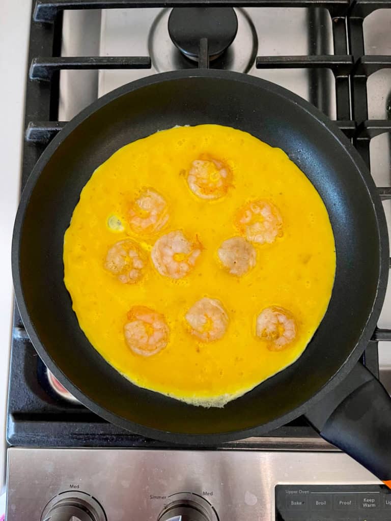 Eggs and shrimp in a pan.