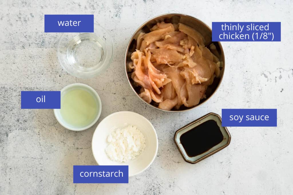 Ingredients displayed for velveting chicken including cornstarch, neutral oil, water, soy sauce and thinly sliced chicken.