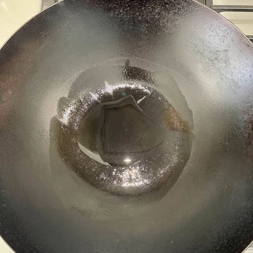 Heated wok with oil.